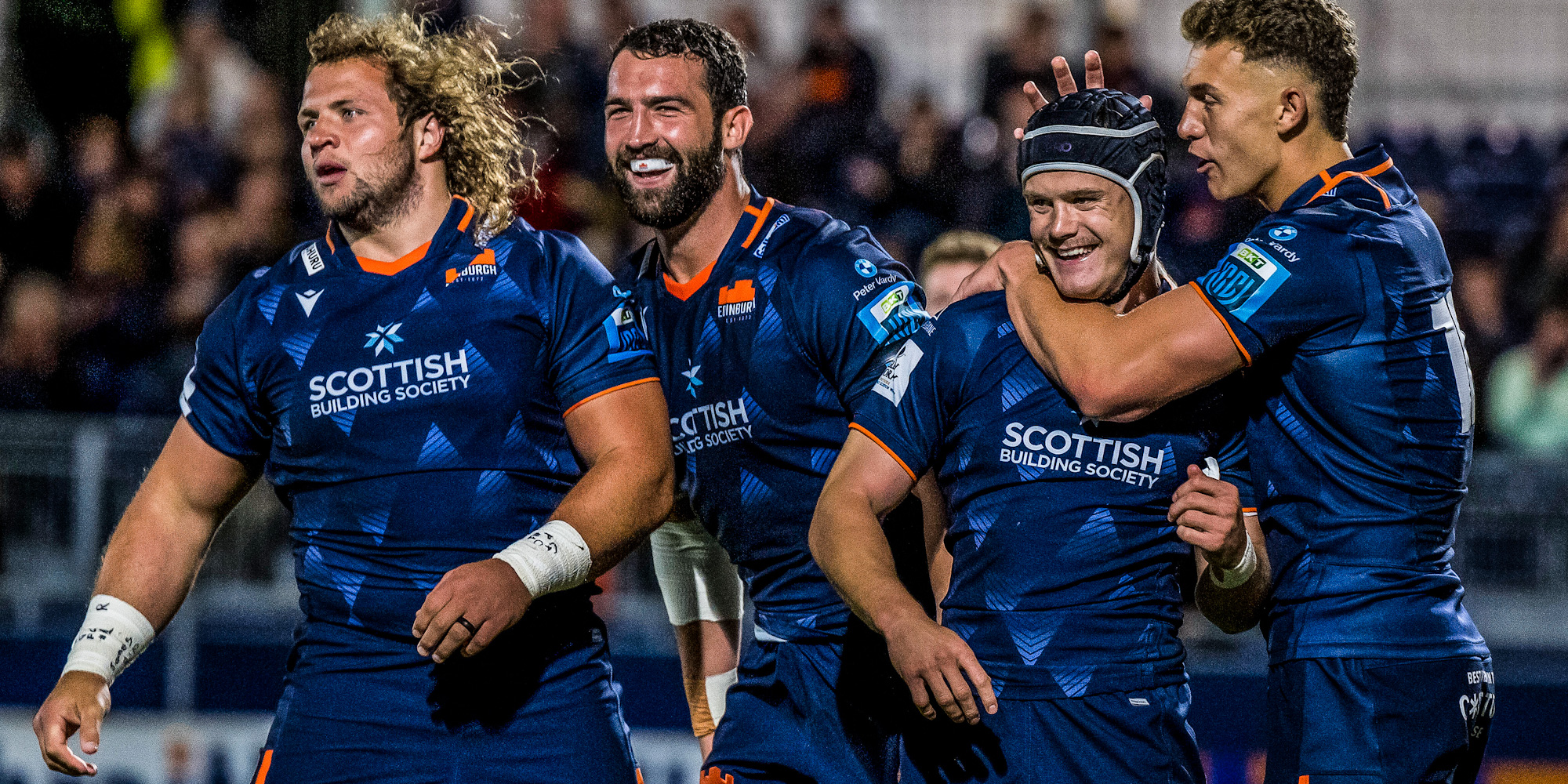 Darcy Swain celebrates his try with his Edinburgh team-mates.